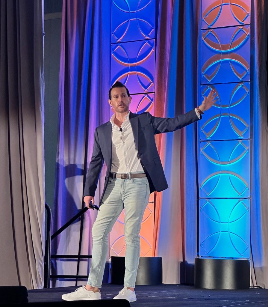 Brian Wright speaking on stage at a Thriving Practice Group event
